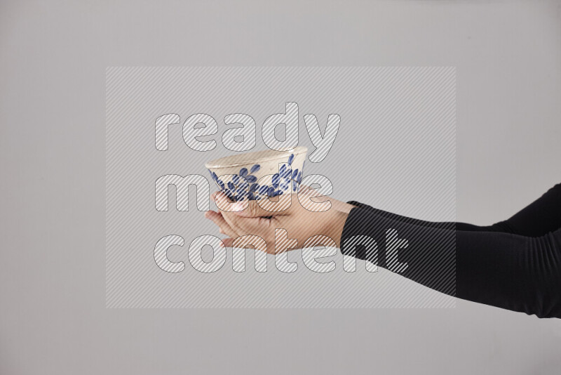 A woman in black abaya holding different pottery essentials in different positions