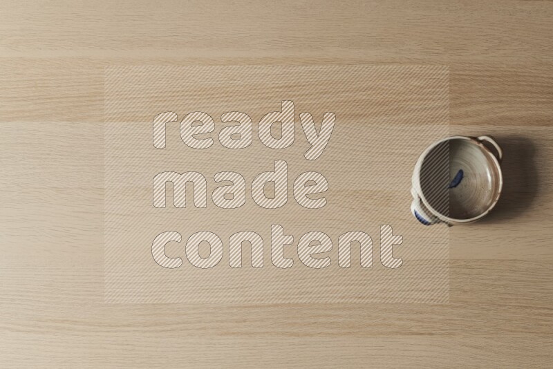 A multicolored pottery bowl on light wooden background