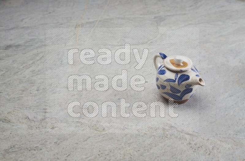 A pottery teapot on grey marble background