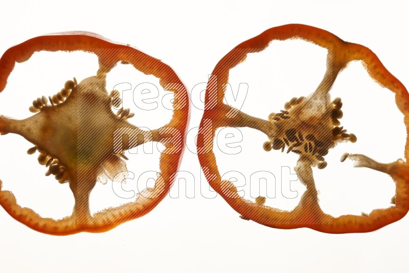 Red bell pepper slices on illuminated white background