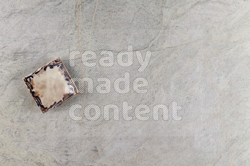 Top View Shot Of A Decorative Pottery Plate On Grey Marble Flooring