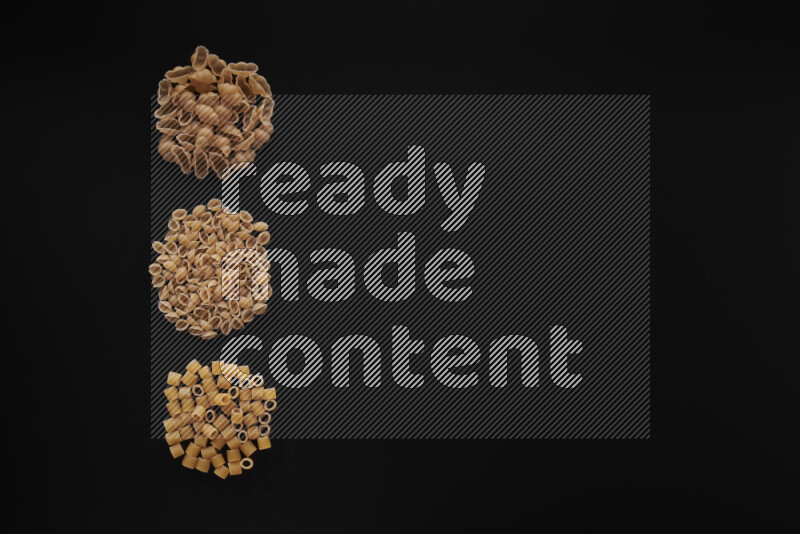 Different pasta types in 3 bunches on black background