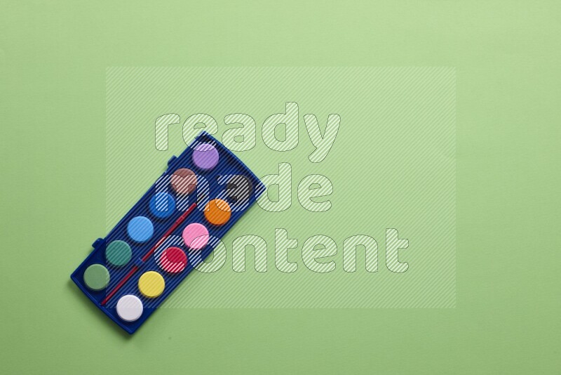 Watercolor paint set on green background