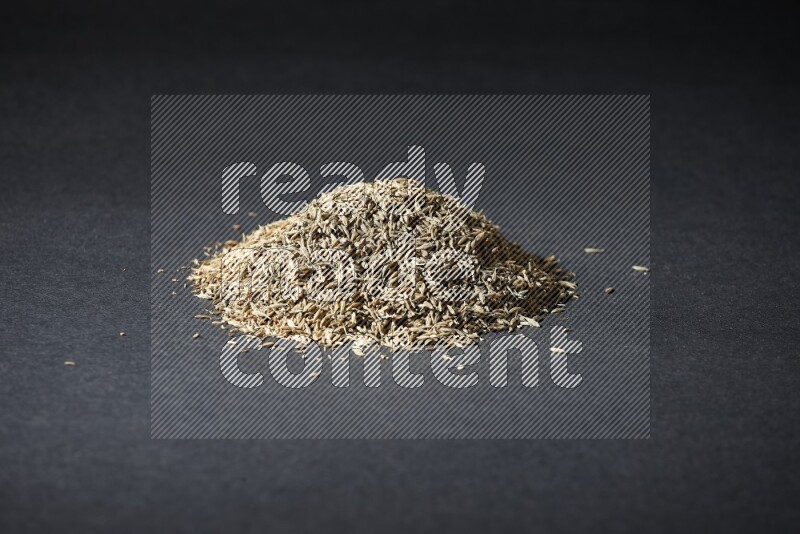 Cumin seeds on black flooring