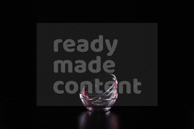 Glassware with rim light in red and white against black background