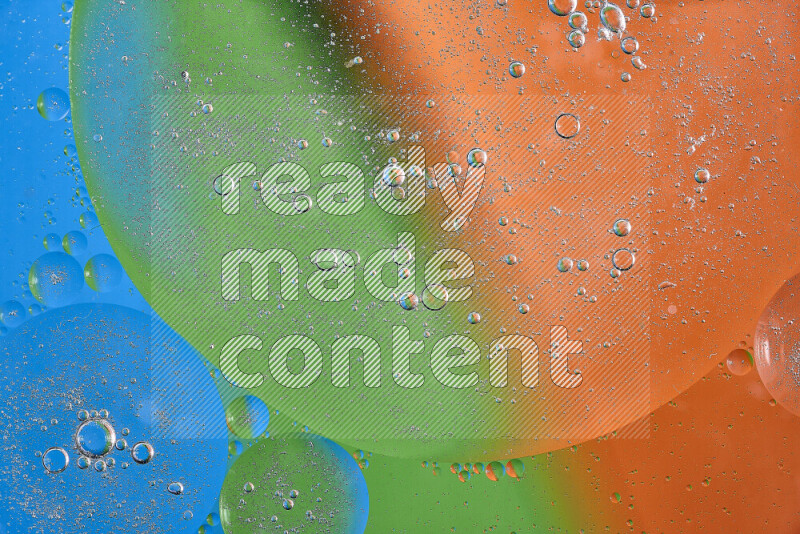 لقطات مقربة لفقاعات من الزيت على سطح الماء باللون البرتقالي والأخضر والأزرق