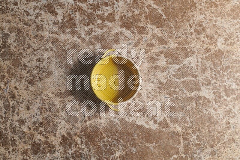 A multicolored pottery bowl on beige marble background
