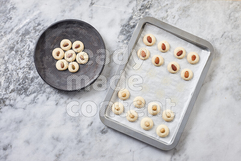 Ghoriba step by step with its ingredient, flour, powdered sugar, ghee and nuts on grey marble background