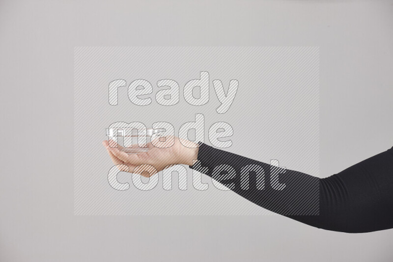 A woman in black abaya holding different glassware in different positions