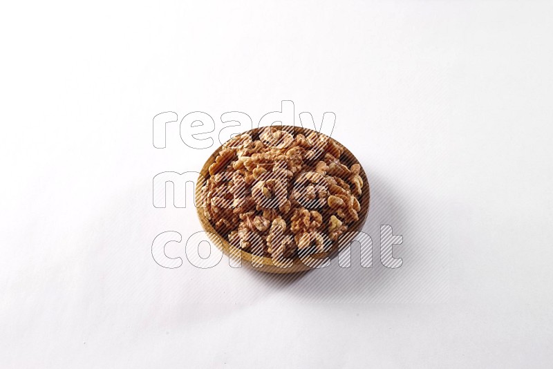 Walnuts in a wooden bowl on white background