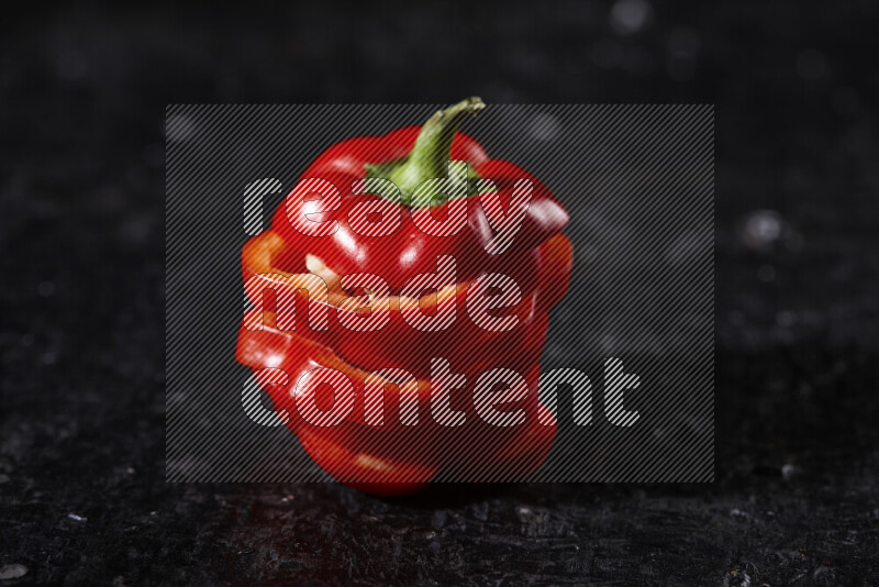 Red bell pepper slices on black background