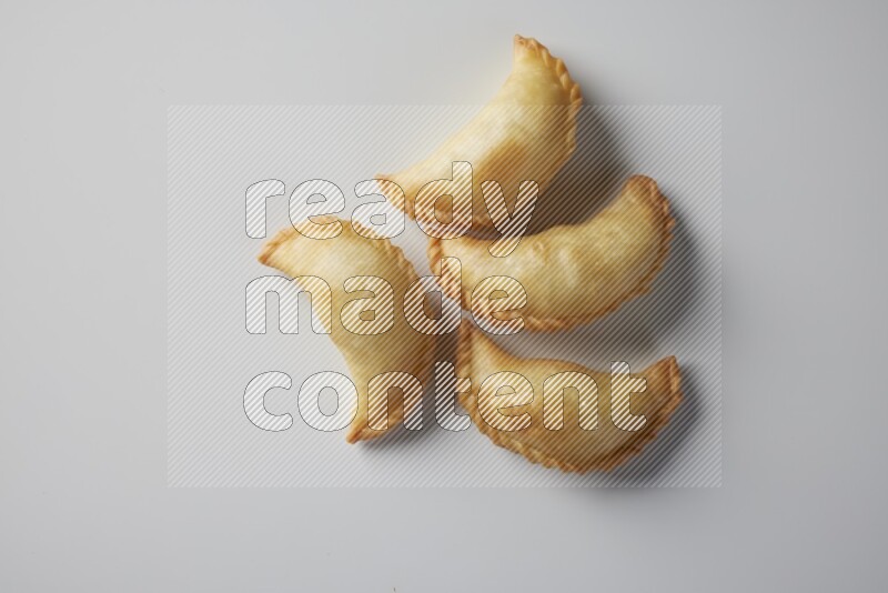 Four fried sambosa from a top angle on a white background