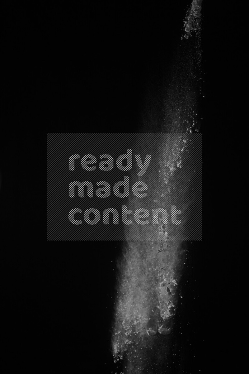 A side view of white powder explosion on black background