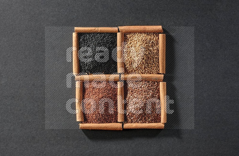 4 squares of cinnamon sticks full of flaxseeds, garden cress, black seeds and mustard seeds on black flooring