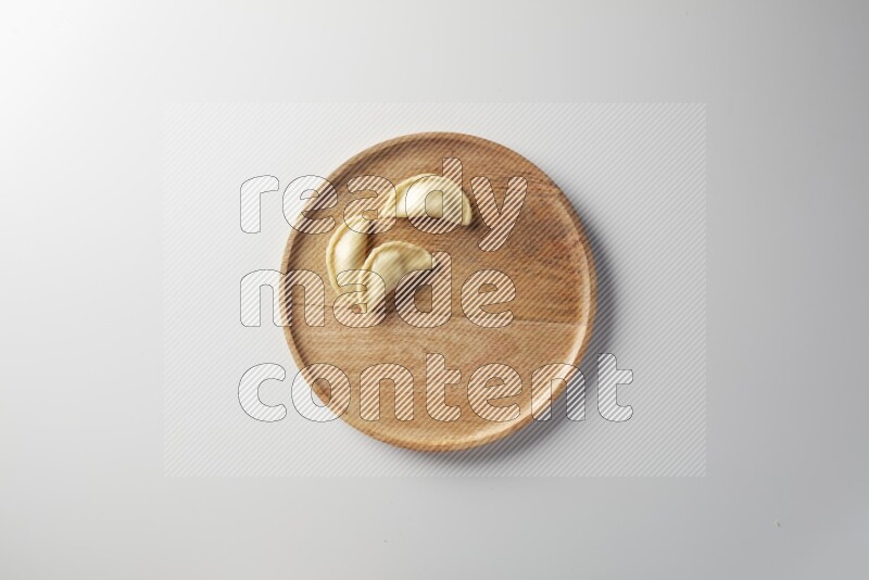 Three Sambosas on a wooden round plate on a white background