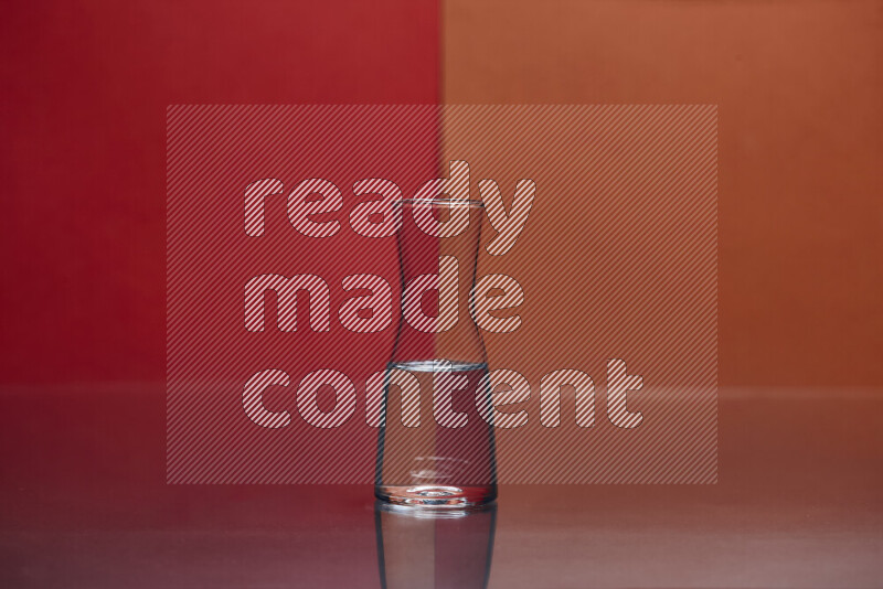 The image features a clear glassware filled with water, set against red and dark orange background