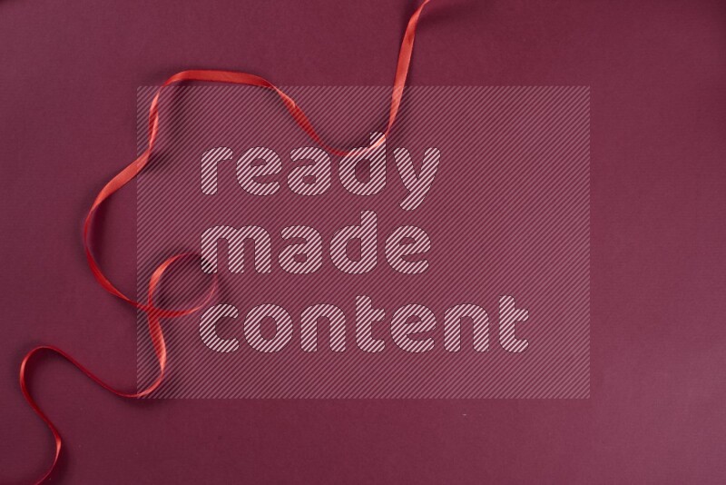 A red collection of sewing and tailoring tools arranged on a red background