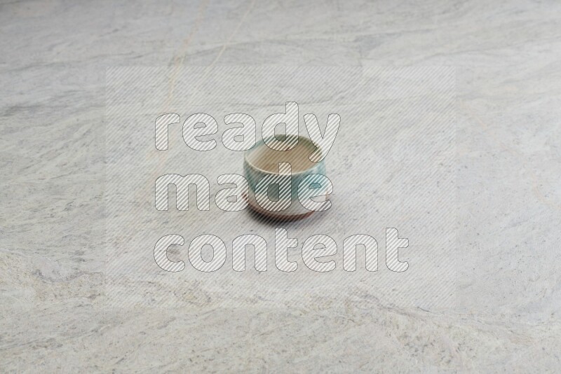 A multicolored pottery bowl on grey marble background