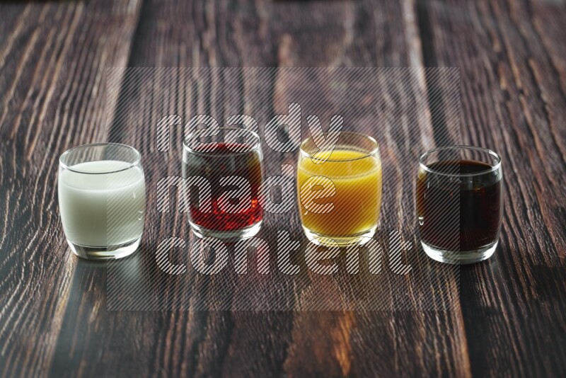 Cold drinks in a glass cup such as water, tamarind, qamar eldin, sobia, milk and hibiscus on wooden background