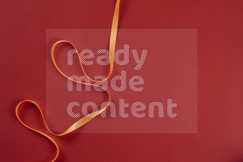 مجموعة من أدوات الخياطة والتفصيل برتقالية اللون على خلفية حمراء