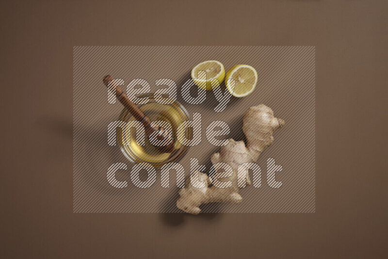 Fresh ginger root with different ingredients such as lemon, orange, honey, ground ginger on beige baackground