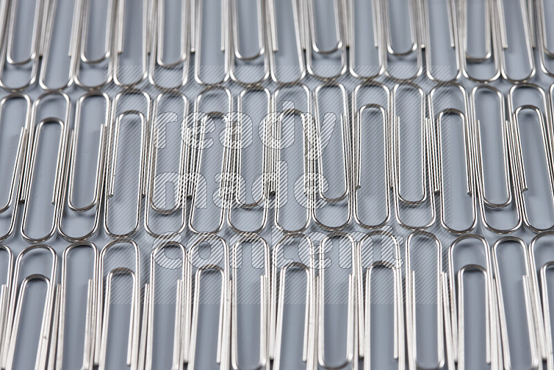 Silver paperclips isolated on a grey background