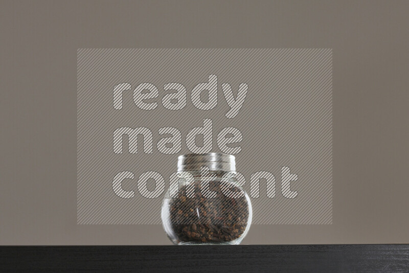 Dried basil in a glass jar on black background