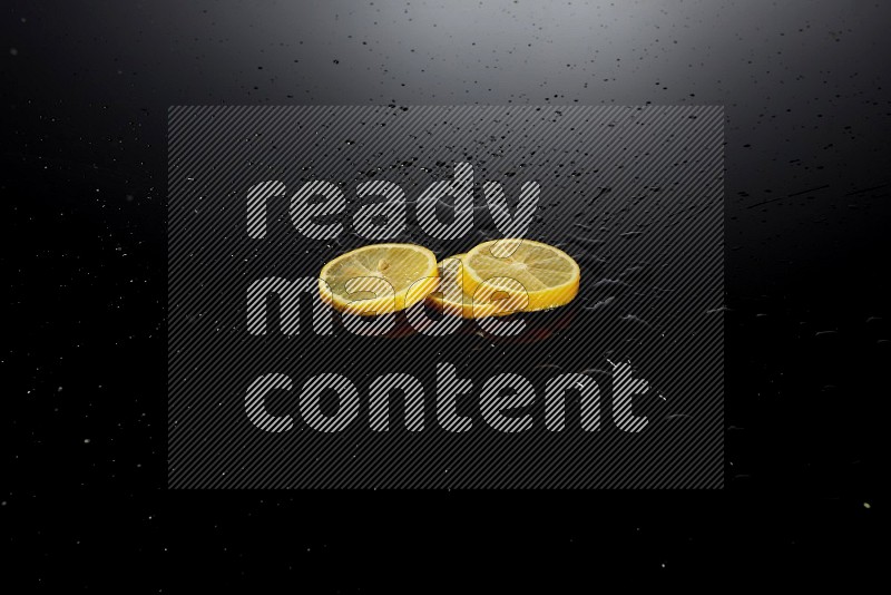 Lemon slices with water drops, and droplets on black background