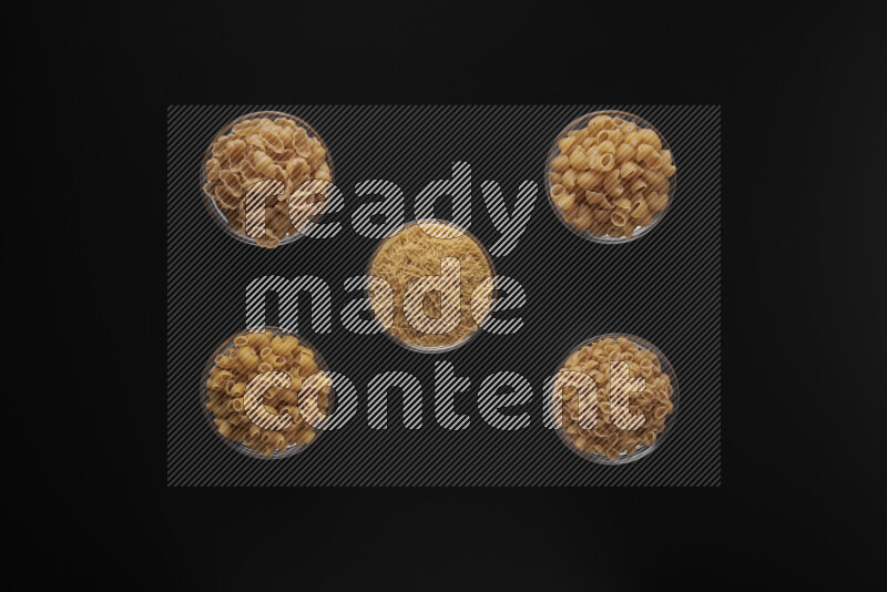 أنواع مختلفة من المعكرونة في أوعية زجاجية علي خلفية سوداء