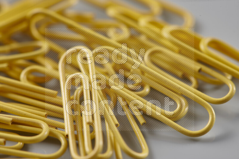 Yellow paper clips isolated on a grey background
