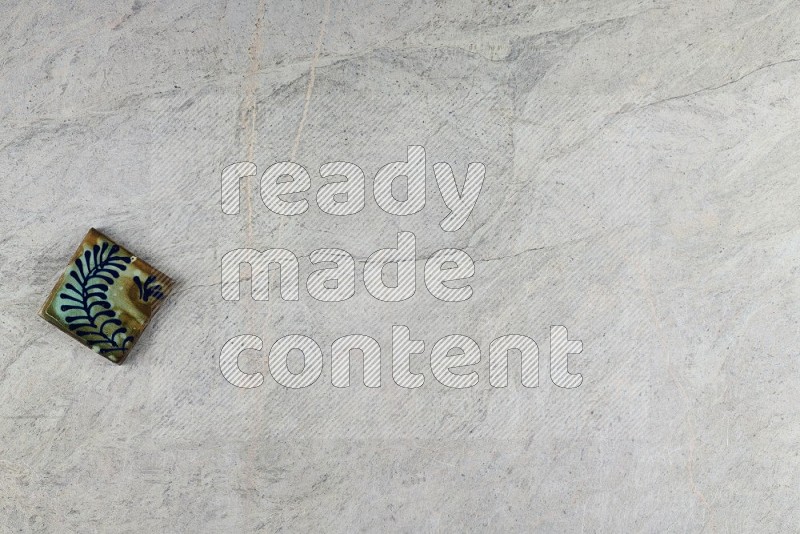 Top View Shot Of A Pottery Coaster tile On Grey Marble Flooring