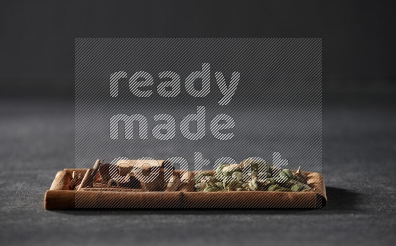 2 squares of cinnamon sticks full of cardamom and cinnamon on black flooring