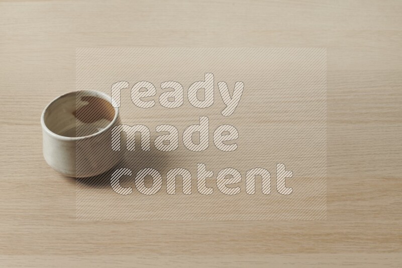 A multicolored pottery bowl on light wooden background