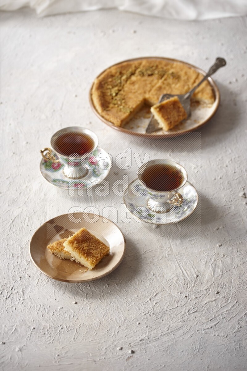 كنافة مع الشاي علي خلفية بيضاء خشبية