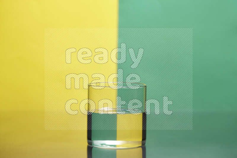 The image features a clear glassware filled with water, set against yellow and green background
