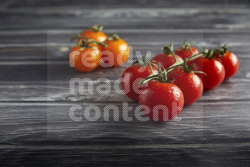 Mixed cherry tomato veins on a textured grey wooden background 45 degree