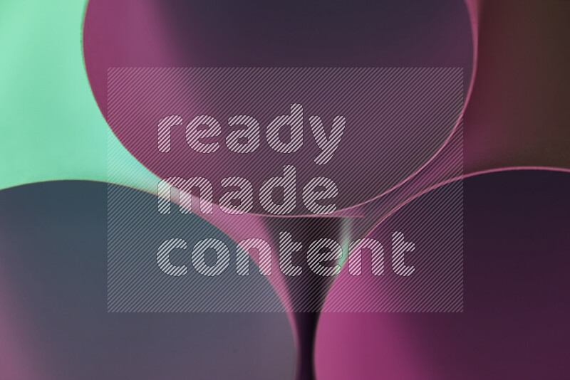 الصورة تعرض فن ورقي تجريدي بأشكال دائرية بدرجات متنوعة من اللون الأخضر والوردي