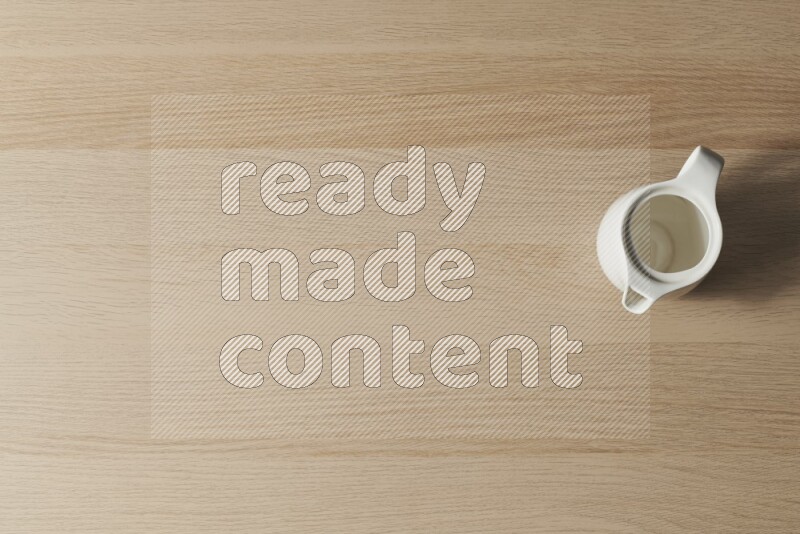 إبريق حليب خزفي على خلفية خشبية فاتحة