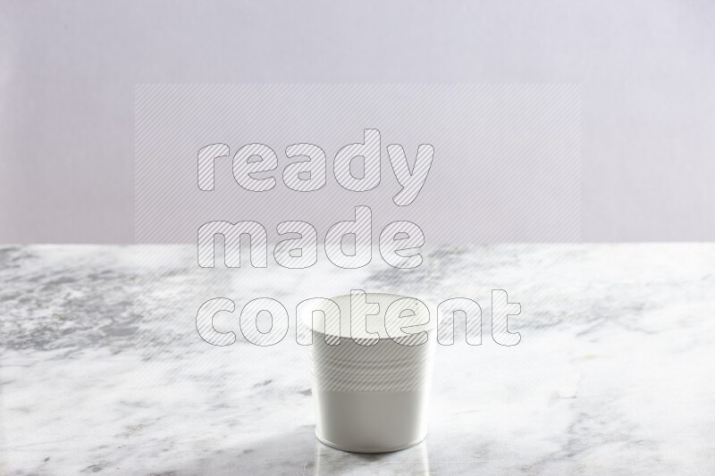 An empty white plant pot on grey marble background