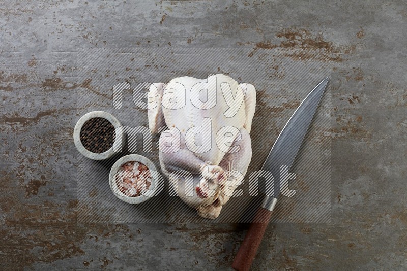 whole raw chicken  direct on a rustic grey background