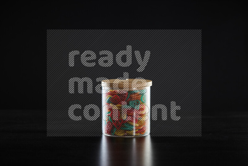 Snacks in a glass jar on black background
