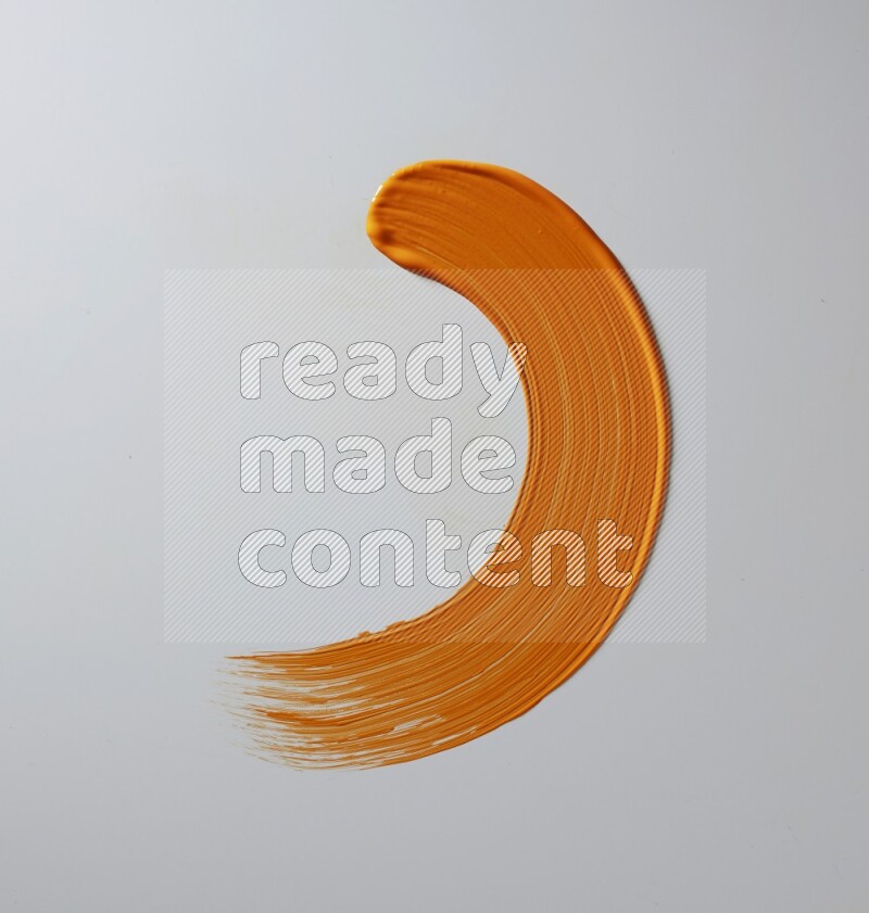 An orange half circular painting brush stroke on white background
