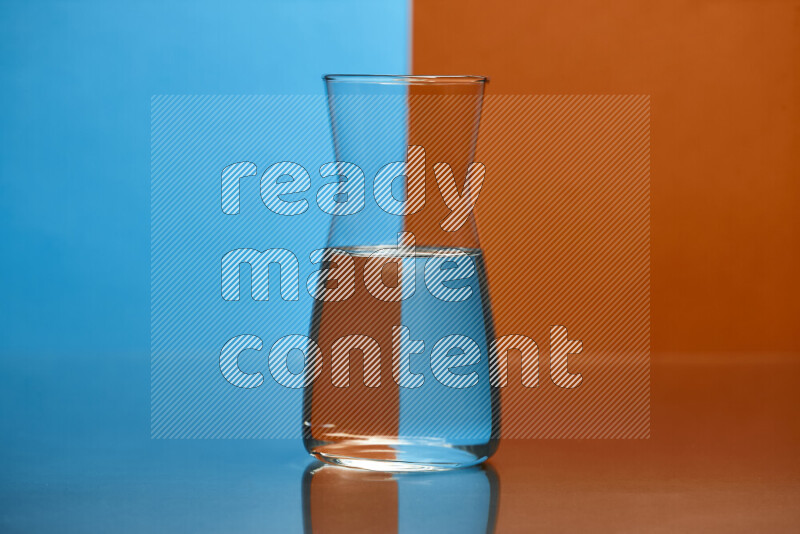 The image features a clear glassware filled with water, set against blue and dark orange background