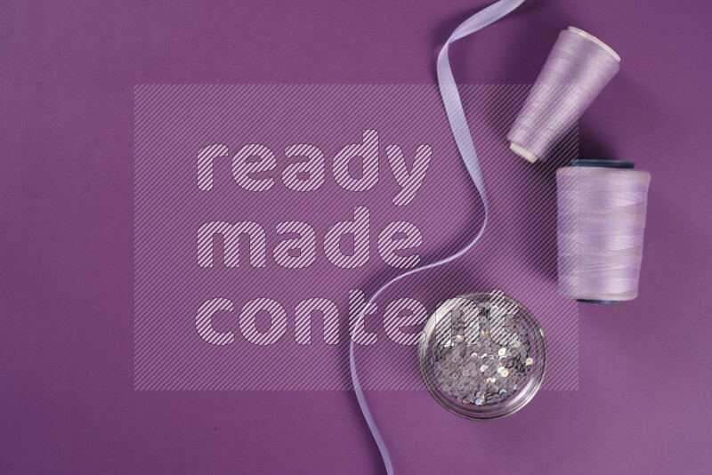 مجموعة من أدوات الخياطة والتفصيل أرجوانية اللون على خلفية أرجوانية