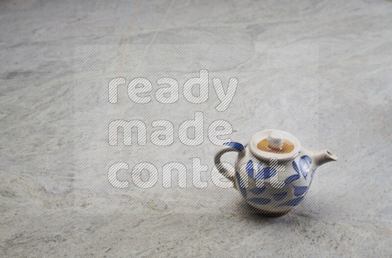 A pottery teapot on grey marble background