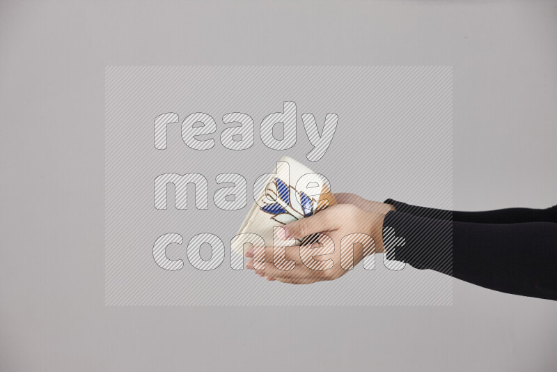 A woman in black abaya holding different pottery essentials in different positions