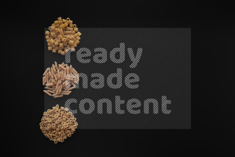 Different pasta types in 3 bunches on black background