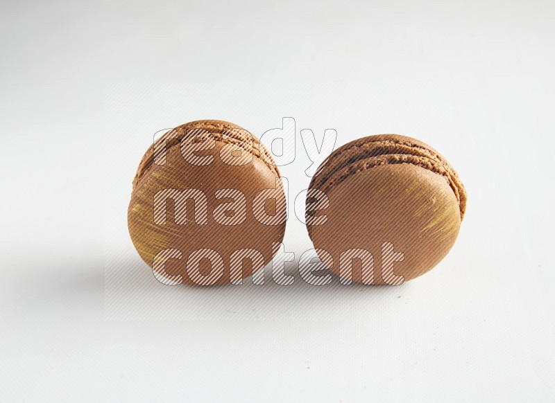 45º Shot of two Brown Coffee macarons on white background