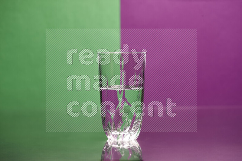 The image features a clear glassware filled with water, set against green and purple background