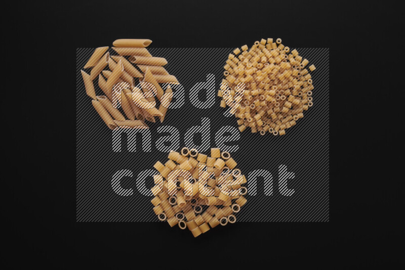 Different pasta types in bunches on black background